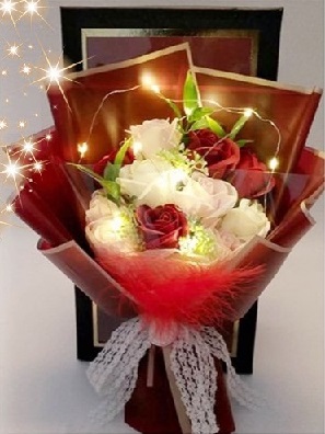 20 White and Red roses wrapped in brown paper and red ribbons with LED light string
